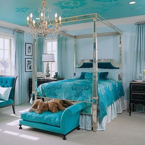 a sophisticated turquoise bedroom with light blue walls and a turquoise ceiling, a canopy bed with turquoise bedding, a turquoise mini sofa, a chandelier