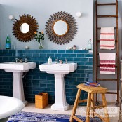 bright blue tiles on the wall and a navy and white printed rug add color to the eclectic bathroom