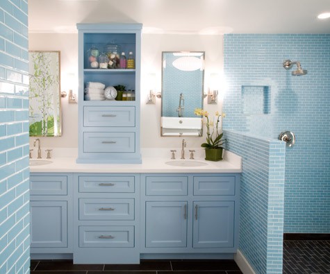 a serenity blue bathroom done with tiles with white grout and a vintage storage unit and vanity