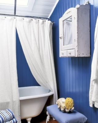 a navy beadboard clad bathroom with much white and matching furniture for a bold look