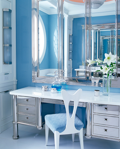 a refined bathroom with light blue tiles, a mirror vanity plus a storage unit