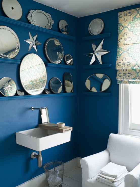 bold blue walls with ledges to display artworks and decorative plates, white elements for a bright feel