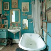 a vintage bathroom with a boho gallery wall, a clawfoot tub, a wall-mounted sink and a chic console