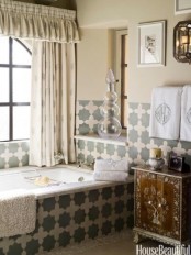 a neutral Moroccan inspired bathroom with Moroccan tiles, an inlay wooden vanity and printed curtains