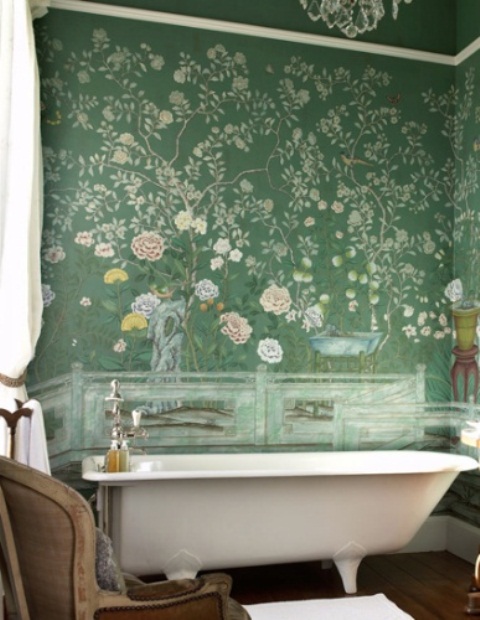 an eclectic bathroom with green floral wallpaper, a free standing bathtub, shabby chic furniture