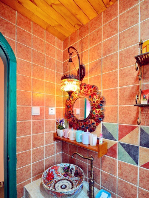 a colorful bathroom with ocher tiles, bright geometric ones, a mosaic mirror and a handpainted vessel sink