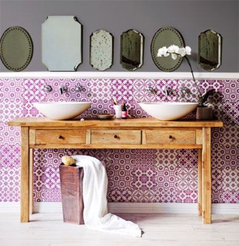 a bright boho bathroom with purple printed tiles, a wooden vanity and an arrangement of Moroccan mirrors