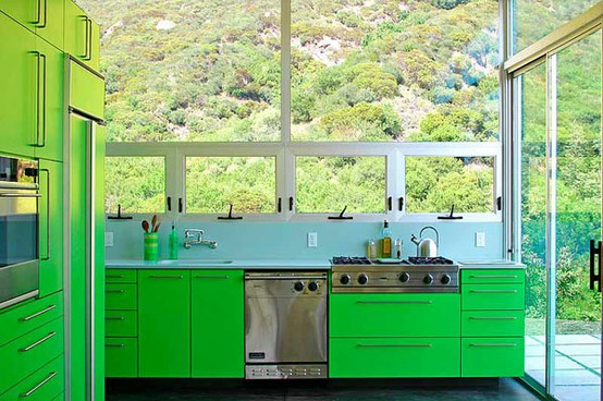 a bright green kitchen with bold cabinetry and stainless steel appliances makes a statement with its color