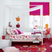 a contrasting girl’s bedroom in white, with a canopy bed and super bold fuchsia and red textiles for an accent, with a red chair, pillows and rugs and bright bags