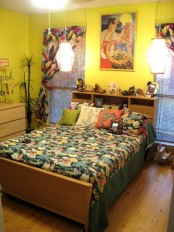 neon yellow walls, a bright artwork and tropical print textiles make this bedroom feel tropical and colorful