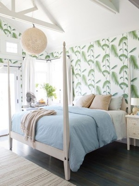 tropical leaf print wallpaper makes the bedroom catchy and creates an ambience, a bed with tall pillars adds to the space
