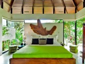 a live edge wooden bed, neon green touches, a live edge headboard and glazed walls that feature tropical views