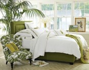 bright green touches, a potted palm tree, a grene printed chair make the bedroom feel tropical