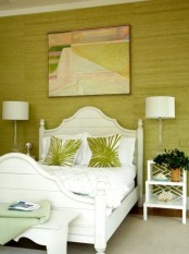 a pistachio statement wall, tropical print pillows and vitnage-inspried white furniture add a tropical feel to the space