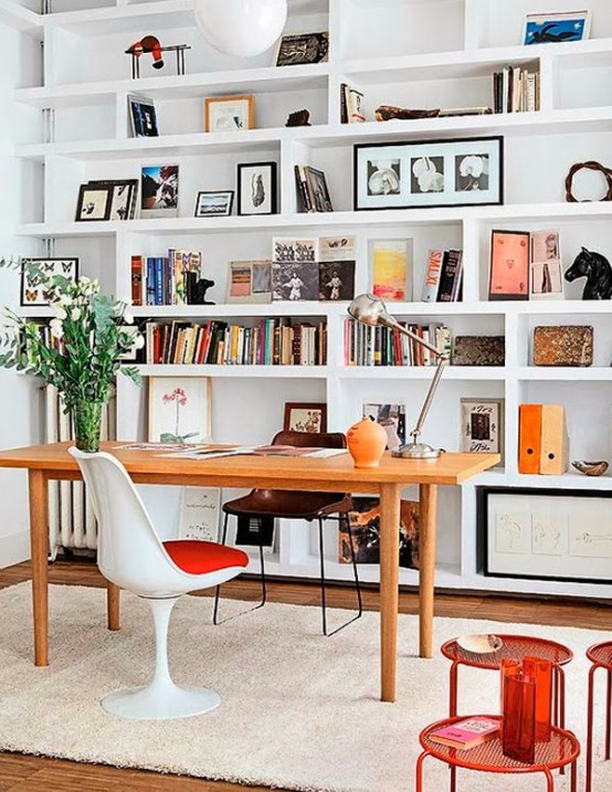 a welcoming and light-filled home office with a whole wall of built-in shelves and some furniture is a cool space to work