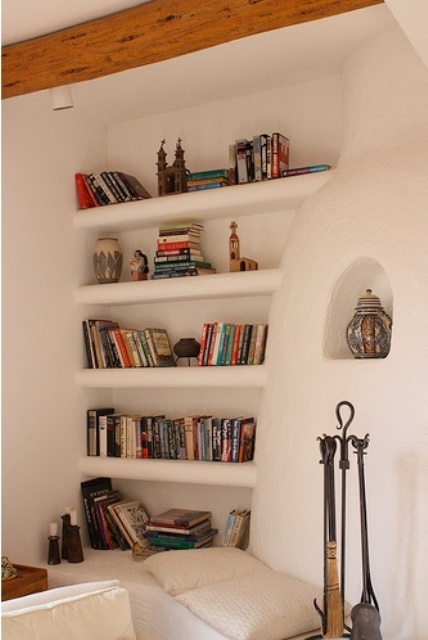 a concrete white wall with built-in shelves where you can place books and other stuff you want