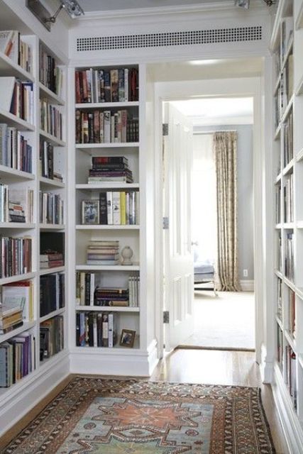 a corridor with built-in bookshelves on both sides is a stylish idea that will save much space and store all your books