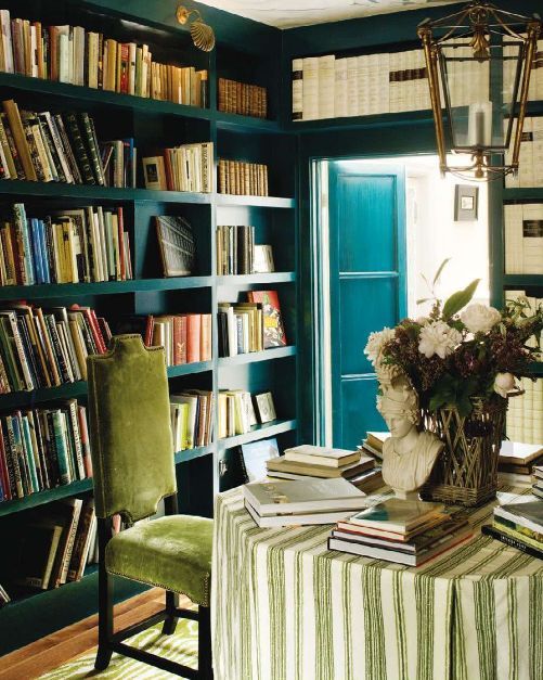 a refined home library with blue built-in bookshelves taking all the walls is a very stylish and cool idea