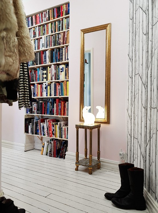 an entryway with lots of built-in bookshelves that allow comfortable storage and doesn't steal space from other rooms