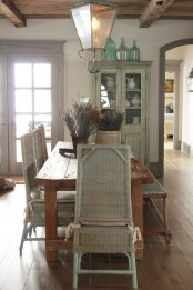 a lovely Provence dining room with a stained table and whitewashed woven chairs, a wooden bench, elegant pendant lanterns and a whitewashed buffet