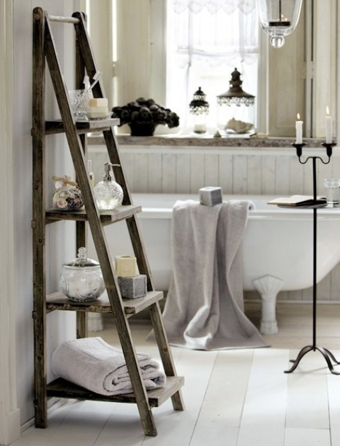 a neutral shabby chic bathroom with a clawfoot tub, a windowsill shelf, a ladder, a candleholder and vintage lamps