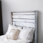a shabby chic bed with a whitewashed headboard and white bedding for an ethereal and airy bedroom