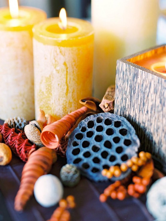 a beautiful fall or Thanksgiving centerpiece of yellow candles, pebbles, lotus slices, berries is a pretty and beautiful idea to rock