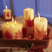 a porcelain tray with pillar candles decorated with fall leaves is a pretty fall or Thanksgiving idea to rock