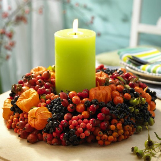 a Thanksgiving centerpiece of berries, seed pods and a neon green pillar candle in the center is a bright and cool solution