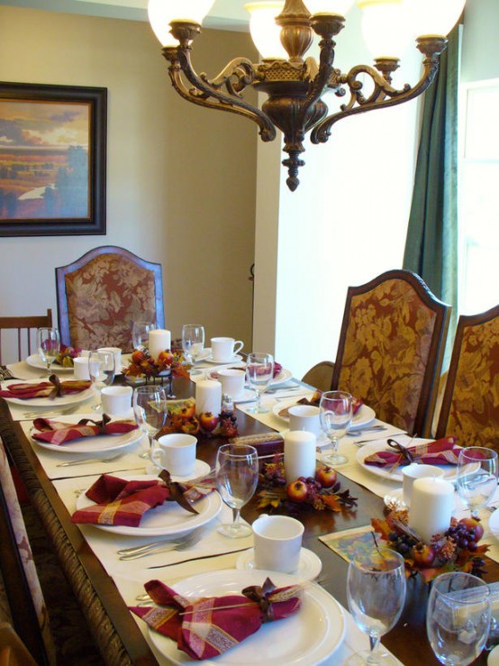 mini Thanksgiving candle centerpieces of pillar candles, faux apples and leaves and burgundy plaid napkins for an accent