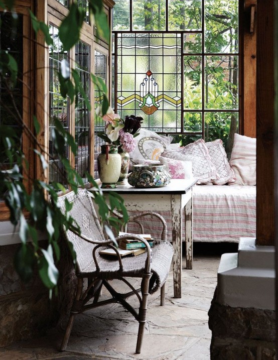 a vintage to shabby chic sunroom with elegant wooden and wicker furniture, pastel textiles, potted greenery and blooms and pastel floral textiles