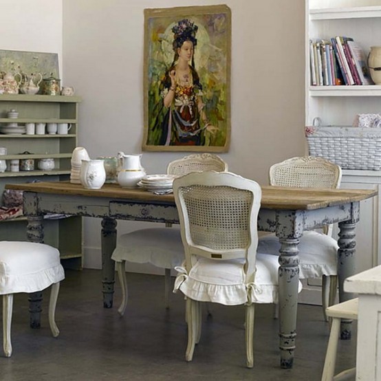 a neutral dining room with a green storage unit, a shabby chic table and neutral vintage chairs plus a statement artwork
