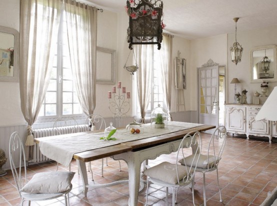 a refined neutral French chic dining room with French windows and neutral curtains, chic vintage dining furniture and a catchy pendant lantern
