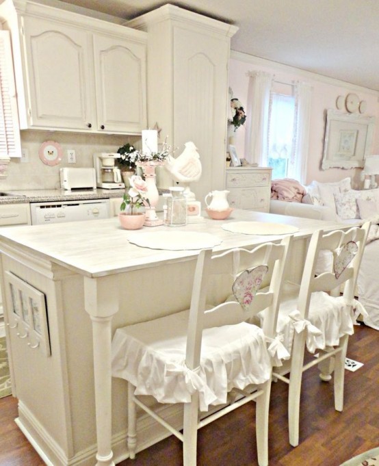 vintage and shabby chic kitchen done in neutrals, with neutral cabinets, floral prints and cute ruffle chair covers