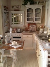 a rustic shabby chic kitchen in neutrals, with wooden walls and vintage cabinets, a shabby chic table and kitchen island and shabby chairs