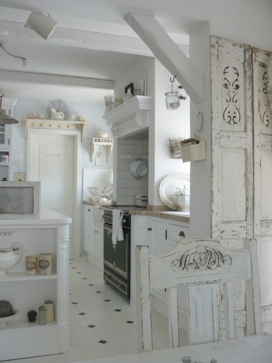 a vintage and shabby chic kitchen with white farmhouse furniture, an art deco cooker with tiles around and a shabby chic dining set