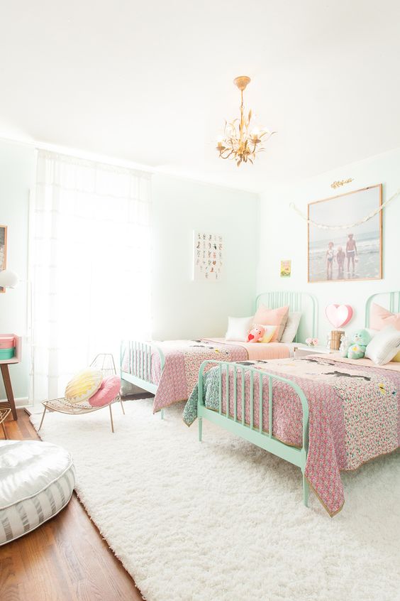 a neutral light filled bedroom with mint colored beds, colorful bedding and pillows, artworks, a desk and some chairs is a stylish and cool space a neutral light-filled bedroom with mint-colored beds, colorful bedding and pillows, artworks, a desk and some chairs is a stylish and cool space