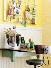 a bright vintage home office with wall paneling, a green wall-mounted desk, a vintage industrial chair and a memo board with notes is a lovely nook