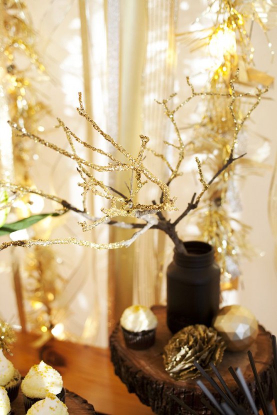 a matte black jar with gold glitter branches is a beautiful and easy to make NYE decoration for your party