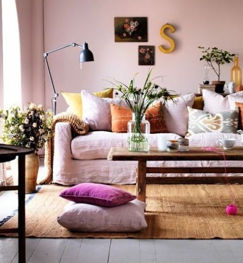 soft pastel and muted color textiles, blush walls and lots of blooms in pots and vases bring a summer feel to the room