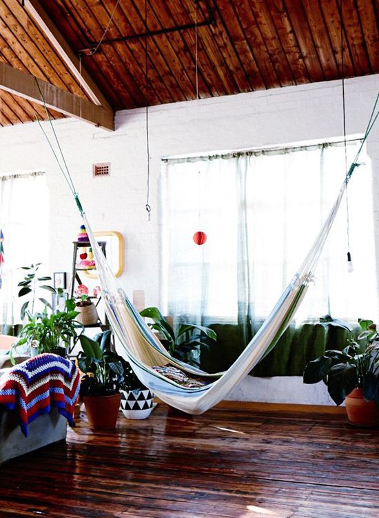 a bright and cheerful summer living room look is achieved with potted greenery, bright textiles and a hammock hung in the center of the room