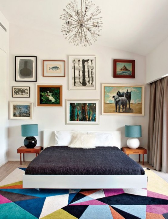 a colorful mid-century modern bedroom with a bright geometric rug, a bed, laconic nightstands and an eclectic gallery wall