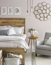 a welcoming mid-century modern bedroom with a pallet wood bed, cozy furniture, artworks and hanging bulbs
