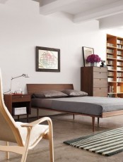 a mid-century modern bedroom with rich-stained furniture, striped rugs and artworks looks very fresh and light-filled