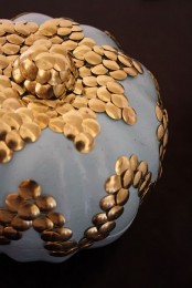a white pumpkin decorated with copper decorative nails creating patterns is a pretty Halloween decoration to DIY