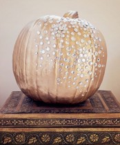 a copper pumpkin decorated with crystals is a beautiful idea for decorating your glam Halloween