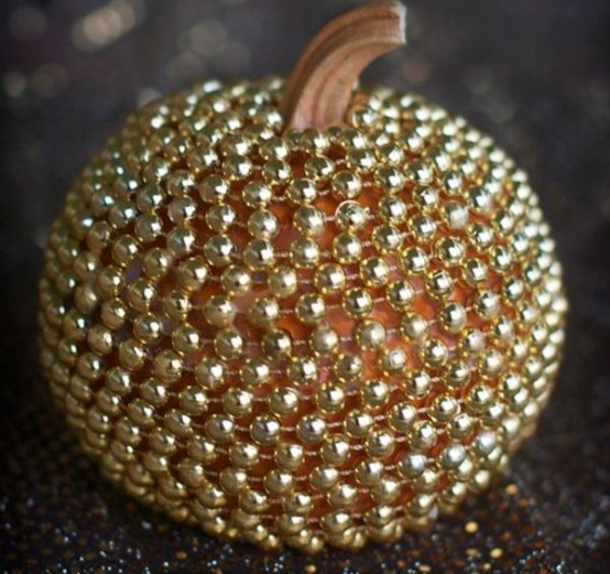 a pumpkin covered with gold beads is a chic and glam decoration you may rock at Halloween