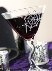 a whimsy cocktail glass accented with a shiny crystal spiderweb is a nice solution for a glam Halloween party
