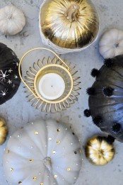 black, grey and gold pumpkins decorated with pompoms, crystla,s polka dots and painted snowflakes for a glam Halloween