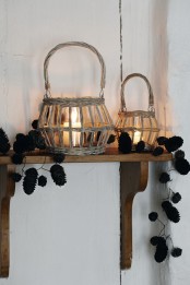 candle lanterns placed in baskets and pinecone garlands on the shelf for a natural fall feel